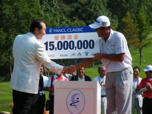 池森賢二大会会長（ファンケル名誉会長）から優勝賞金１５００万円のチェックを受け取る高見和宏（右）。賞金ランキング１位に浮上した（裾野ＣＣ）