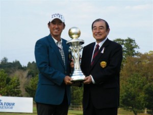 シニア初優勝のカップを富士フィルム・古森重隆社長（右）から受ける喜びの芹澤信雄（左）＝富士フィルムシニア