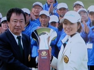 梅村大会会長（ヤマハ社長＝左）から優勝カップを受ける喜びの比嘉真美子（右）＝BS朝日から