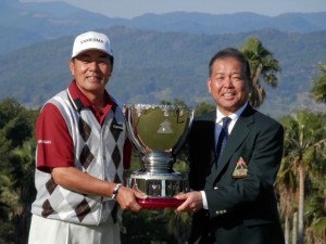 １３年シニアツアー最終戦、いわさき白露シニアでシーズン３勝目。ＰＧＡ・森　静雄会長（右）から優勝カップを受ける室田淳（左）。賞金王に花を添えた（鹿児島・いぶすきＧＣ開聞コース）