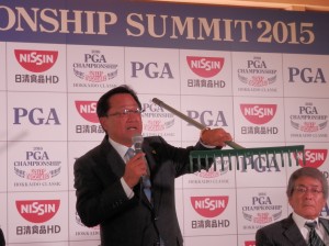 セント・アンドルーズから取り寄せたバンカーレーキをかざして説明するＰＧＡ倉本昌弘会長（北海道クラシックＧＣ＝１５年８月３１日）