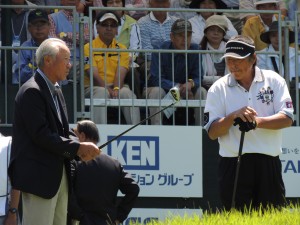 青木功ＪＧＴＯ会長（左）の激励を受けたジャンボ（右）。青木会長はジャンボのアイアンを握ってスタート前のジャンボに話しかけた（６月、日本ゴルフツアー選手権＝茨城・宍戸ヒルズ）